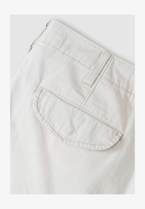 Hvide bomuldsbukser med en buet baglomme med diskrete syningsdetaljer. Stoffet har en glat tekstur og et lige snit.