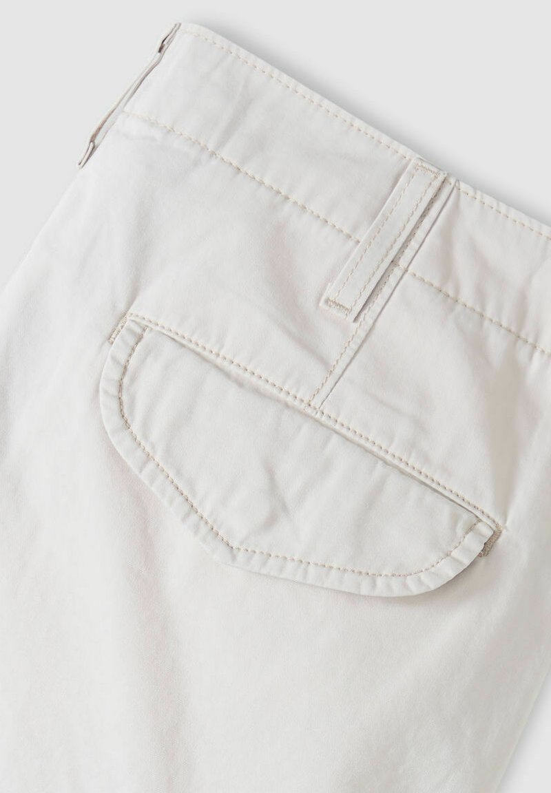 Un pantalon en coton blanc présente une poche arrière incurvée avec des détails de couture subtils. Le tissu a une texture lisse et un design à coupe droite.
