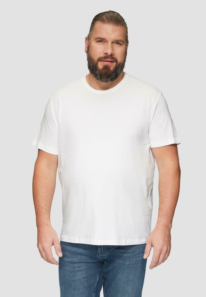 Weißes Baumwoll-T-Shirt mit kurzen Ärmeln, rundem Halsausschnitt und lockerer Passform, kombiniert mit blauen Jeans. Keine sichtbaren Muster oder Logos.