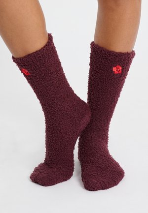Calze pelose bordeaux realizzate in un materiale texturizzato e morbido; presentano un piccolo accento floreale rosso vicino alla parte superiore.