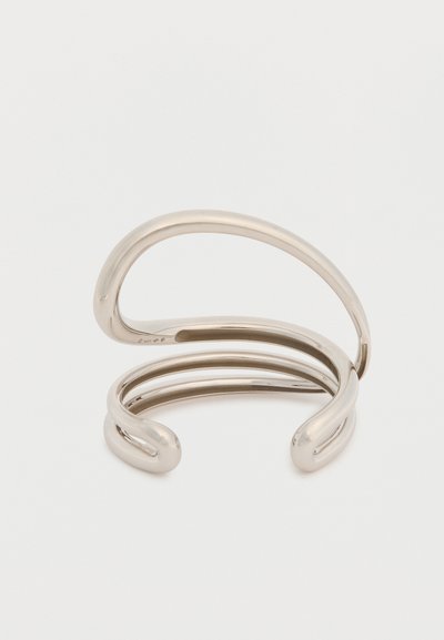 Ανοιχτό βραχιόλι ασημί απόχρωσης με μοντέρνο, κυκλικό σχέδιο που διαθέτει τρεις διασυνδεδεμένες καμπυλωτές λωρίδες σε λευκό φόντο.