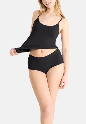 Svart camisole med tunna axelremmar och matchande högmidjade trosor. Båda plaggen har ett slätt, elastiskt tyg och minimala sömmar.