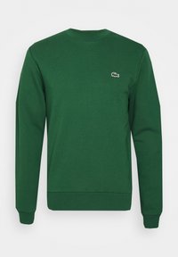 Sudadera de algodón verde con cuello redondo, mangas largas, puños y dobladillo acanalados, que presenta un pequeño logo bordado en el pecho.