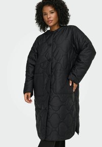 Juodas, pūstas ilgas paltas su apvalia iškirpte, ilgomis rankovėmis, sagomis užsegamas užtrauktukas ir dviem priekinėmis kišenėmis, dekoruotas tekstūriniu bangelių raštu.