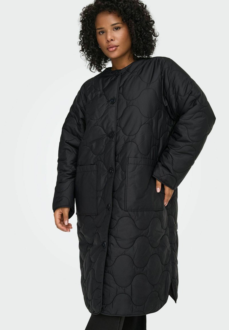 Juodas, pūstas ilgas paltas su apvalia iškirpte, ilgomis rankovėmis, sagomis užsegamas užtrauktukas ir dviem priekinėmis kišenėmis, dekoruotas tekstūriniu bangelių raštu.