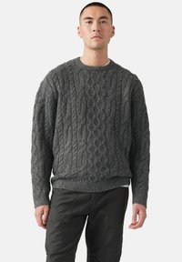 Suéter gris de punto trenzado con cuello redondo acanalado y puños. Confeccionado en un tejido grueso y texturizado, presenta un corte holgado y forma cuadrada.