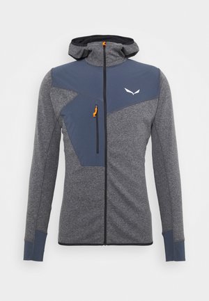 Harmaa urheilutakki, jossa on istuva huppu, kontrastiväriset tummanharmaat paneelit, oranssi vetoketjun vedin ja valkoinen logo rinnassa.