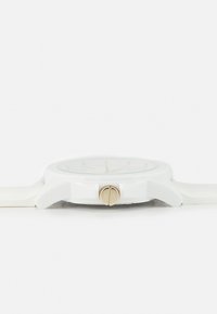 Orologio da polso bianco con quadrante rotondo, hardware color oro, design minimalista e cinturino in silicone liscio. Le caratteristiche principali includono semplici marker delle ore.