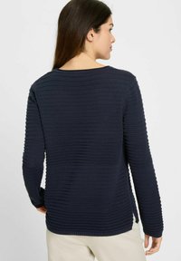 Navyblauer, strukturierten Pullover mit horizontalen Rippungen, langen Ärmeln, Rundhalsausschnitt und seitlichen Schlitzen für mehr Bewegungsfreiheit.