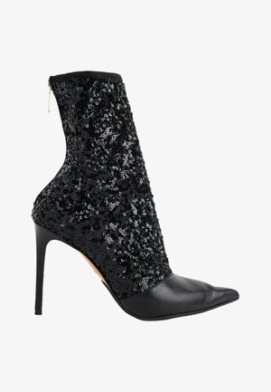 Bottine noire à talon haut, bout pointu et tige en tissu recouverte de sequins, avec fermeture éclair à l'arrière.