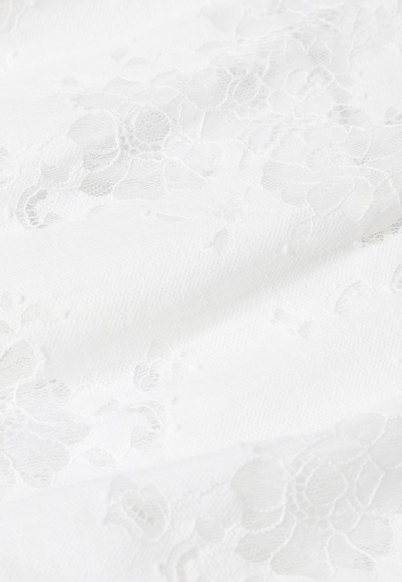 Weißes Spitzengewebe mit Blumenmustern, feiner Textur und sanftem Fall. Die Oberfläche zeigt filigrane Details und einen subtilen Glanz.