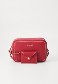 Borsa a tracolla rossa in pelle con cuciture bianche, chiusura con zip, accessori in oro e pochette mini rimovibile. Nome del brand impresso sul davanti.