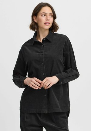 Zwarte corduroy shirt met een knoopsluiting aan de voorkant, kraag en lange mouwen. Heeft een relaxte pasvorm en een gestructureerd oppervlak, ideaal voor het lagen van kleding.