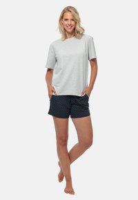 Lichtgrijze katoenen t-shirt met korte mouwen, gecombineerd met marineblauwe shorts met witte stippen. Comfortabele pasvorm met zakken.