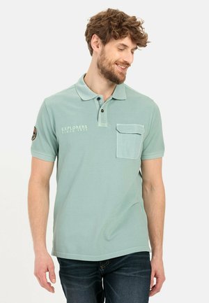 Hellgrünes Poloshirt mit kurzen Ärmeln, Knopfkollier, einer Brusttasche und besticktem Text. Weiches Material mit einer genauen Passform.