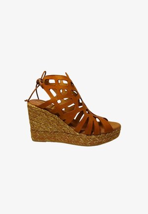 Sandalo wedge in pelle color cuoio con design a intaglio, tacco in juta naturale intrecciato e cinturino alla caviglia regolabile. Soletta confortevole per un supporto ottimale.