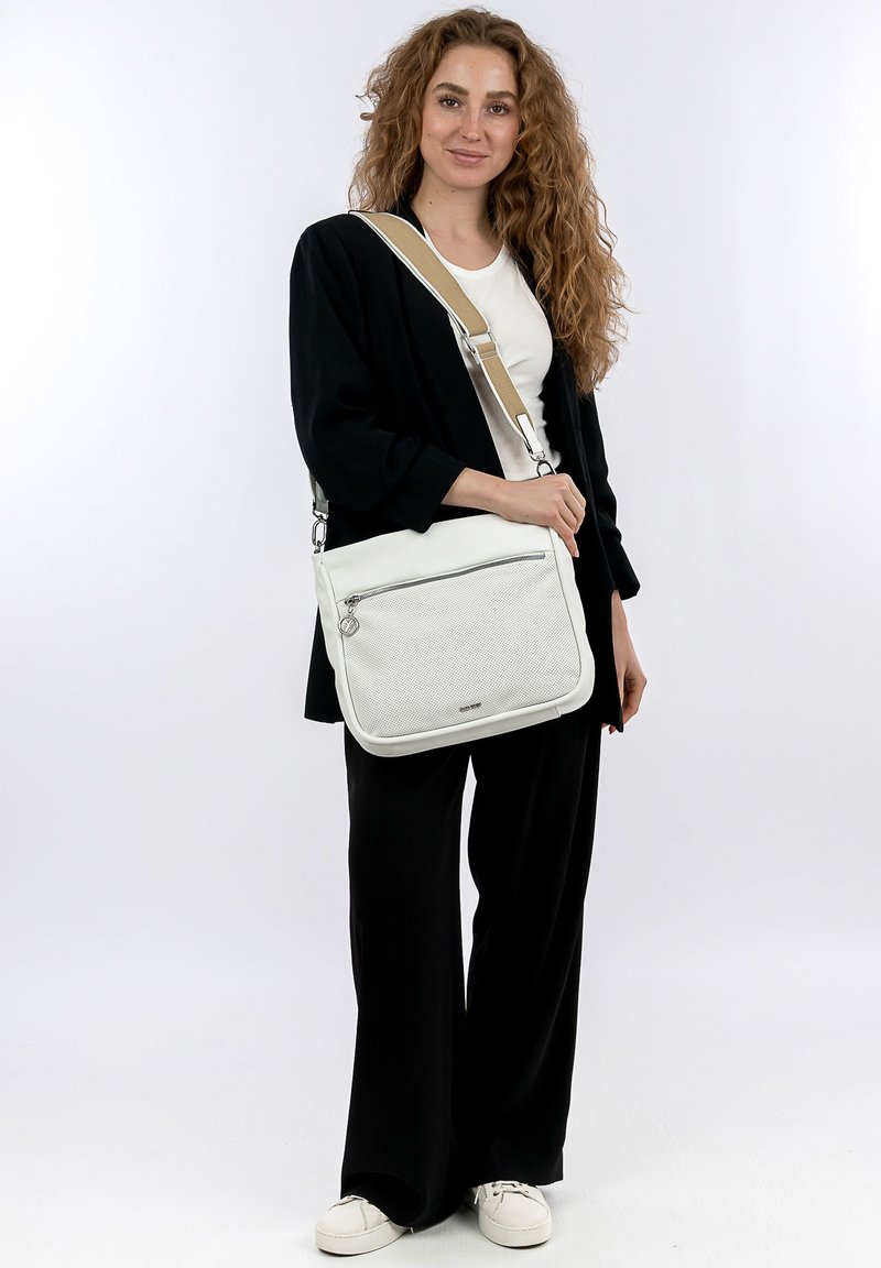Borsa a tracolla bianca con una parte frontale testurizzata, tasca con zip e tracolla regolabile beige, presentata su uno sfondo bianco.