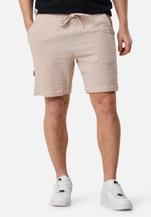 Shorts en coton texturé beige avec taille élastique et cordon de serrage, dotés de poches latérales et d'une finition ourlée.