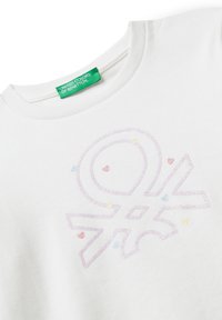 Weißes Baumwoll-T-Shirt mit Rundhalsausschnitt und einem glänzenden, mehrfarbigen Logo-Druck. Rund um das Design sind dekorative kleine Herzen in Pastellfarben.