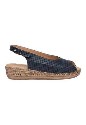 Sandalia slingback de piel trenzada en azul oscuro con punta abierta, que cuenta con un tacón cuña envuelto en yute y correa ajustable con hebilla.
