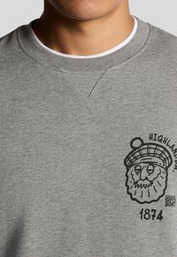 Felpa grigia con scollatura a girocollo. Presenta una grafica nera di un uomo con barba e cappello, con la scritta "HIGHLANDS" e "1874".