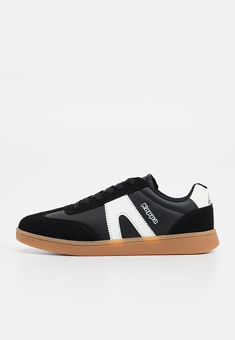 Chaussures de sport noires avec un dessus en cuir lisse et des accents en daim. Le logo et les éléments de design blancs contrastent avec la semelle en caoutchouc gomme.