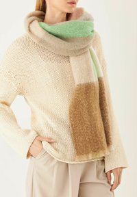 Écharpe en laine avec des sections vert menthe, pêche clair, beige et marron ; texture douce avec un design épais et superposé.