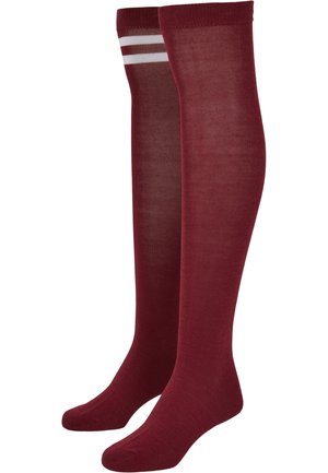 Knielange burgunderrote Socken mit glatter Textur, die zwei weiße horizontale Streifen nahe der Oberseite und eine verstärkte Zehenpartie aufweisen.