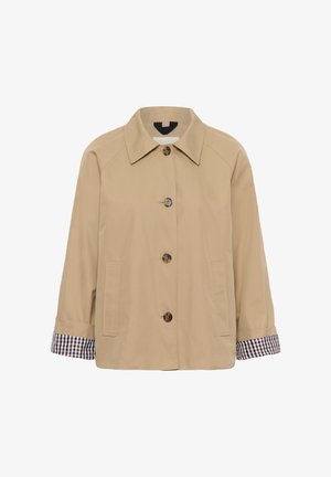 Beige gombos kabát gallérral, két elülső zsebbel, és a feltekert ujjakon látható kockás bélésű mandzsettákkal.