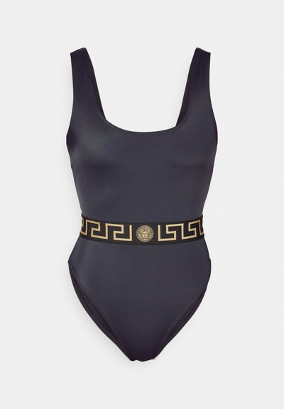 Melnā viengabala peldkostīms ar apaļu kakla izgriezumu, ar zelta rakstainu jostu un emblemu jostasvietā. Eleganta, gluda auduma tekstūra.