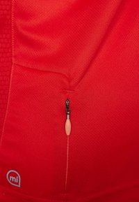 Textil rojo con una superficie lisa y texturizada, con un detalle de cremallera. La cremallera tiene un tirador de metal negro y una pestaña de color claro.