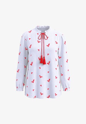 Witte blouse met lange mouwen met rode geborduurde hartpatronen, geplooide kraag en rode tassellinten bij de hals.