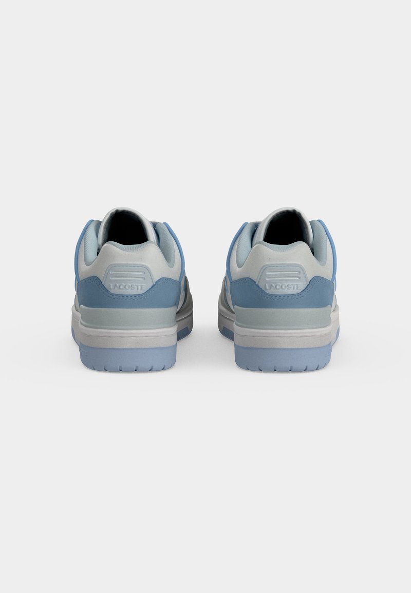 Paar graue und hellblaue Lacoste-Sneakers, von hinten auf weißem Hintergrund gezeigt.
