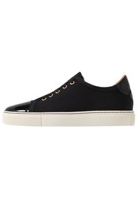Sneakers neri in tela con punta e pannello posteriore in pelle verniciata, occhielli dorati e suola in gomma bianca. Design semplice e lineare.