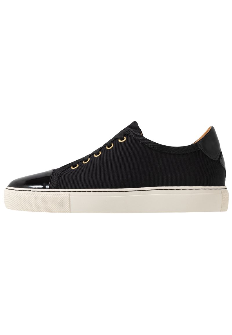 Sneakers neri in tela con punta e pannello posteriore in pelle verniciata, occhielli dorati e suola in gomma bianca. Design semplice e lineare.