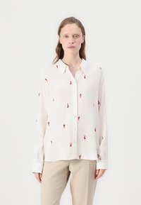 White long-sleeve shirt with red and black embroidered patterns, button-up front, and a classic collar. Smooth fabric with relaxed fit.