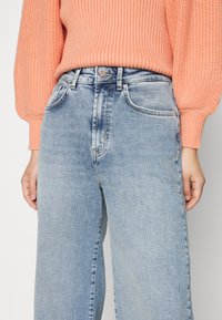 ONLY Petite ONLINC HOPEEX HI WIDE LEG REAPET - Calças de ganga de corte relaxado - light blue denim
