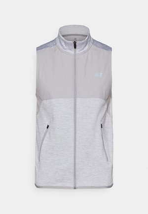 Gilet sans manches gris en tissu léger. Doté d'un col montant, d'une fermeture éclair sur toute la longueur et de deux poches latérales. Accents texturés aux épaules.