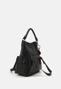 Sac à main noir avec visages de Mickey Mouse embossés, poignée supérieure tressée, bandoulière amovible et poche à fermeture éclair à l'avant, sur fond blanc.