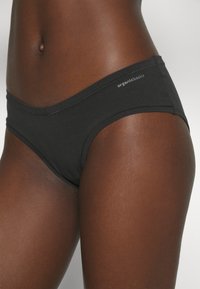 Black organic cotton briefs with a low-rise design, featuring a smooth texture and subtle branding along the waistband.