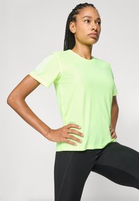 Limoengroen sport T-shirt met een ronde hals, korte mouwen en drie witte horizontale strepen op elke schouder.
