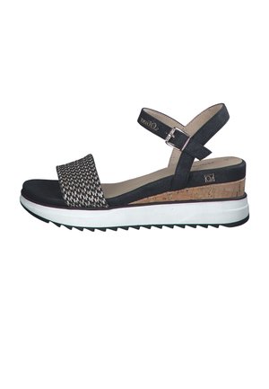 Black sandals featuring a textured fabric upper, cork midsole, white rubber outsole, and adjustable ankle strap for secure fit.