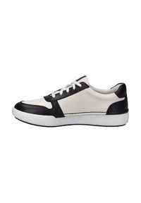 Leather sneaker with a white body and black accents. Features a rounded toe, perforated detailing, and white laces on a textured sole.