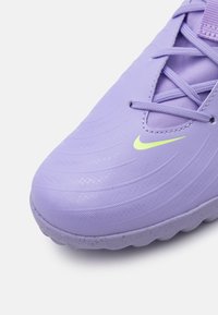 Lilla syntetiske sneakers med tekstureret overdel, der har grøn Nike-logo, symmetrisk snøresystem og gummisål.