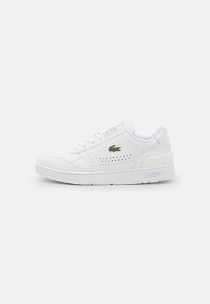 Biała skórzana sneakersy z perforowanymi akcentami, okrągłym czubkiem, płaską gumową podeszwą i haftowanym zielonym logo Lacoste po zewnętrznej stronie.