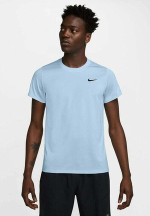Hele sinine lühikeste varrukatega Nike T-särk ümmarguse kaelusega ja musta logoga rinnal. Kangas näeb välja siledana ja kerge.