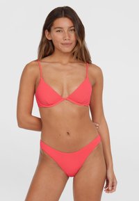 Coral bikini set featuring a textured fabric, triangular cup bra with adjustable straps, and low-rise thong bottom.