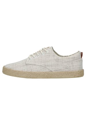 Beiger Sneaker aus Stoff mit niedrigem Schnitt, weißen Schnürsenkeln und Absatz im Jute-Stil, von der Seite gesehen.