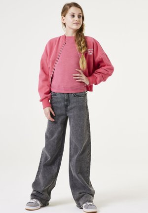 Sweat-shirt rose court et jean large gris avec une taille élastique. Le sweat-shirt a une fermeture éclair devant et un détail de logo.