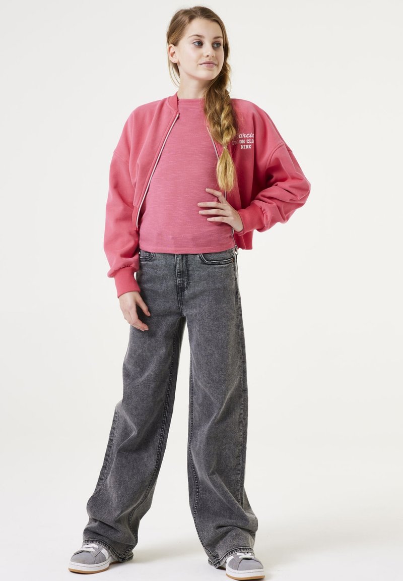 Sweat-shirt rose court et jean large gris avec une taille élastique. Le sweat-shirt a une fermeture éclair devant et un détail de logo.